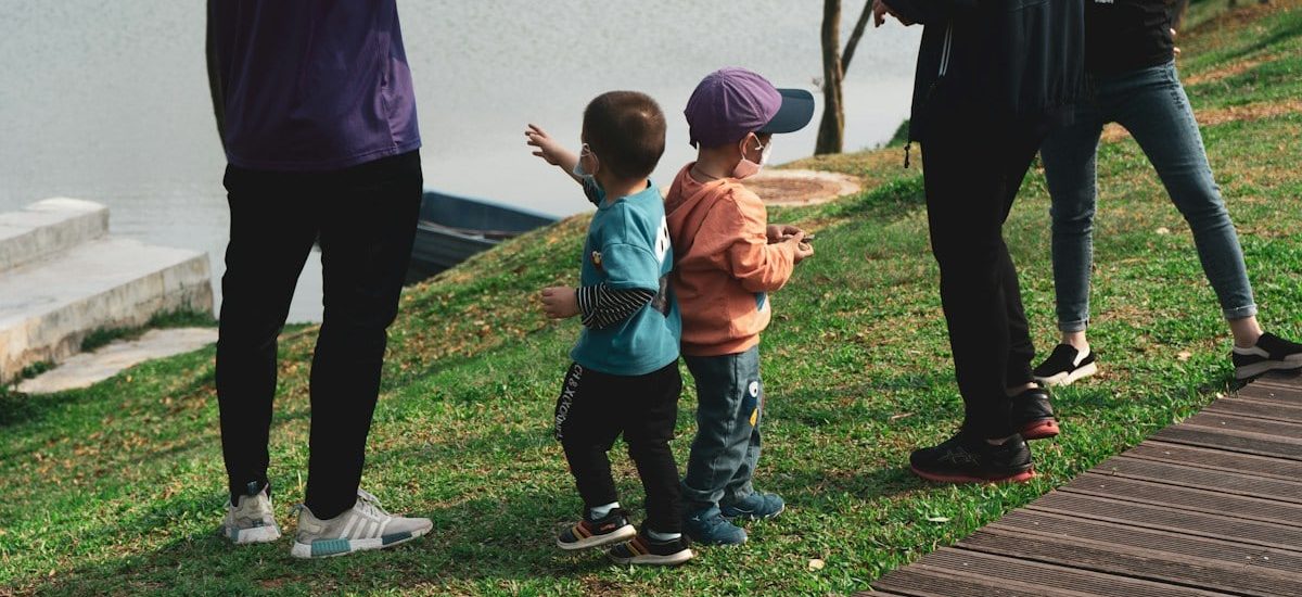 man in blue crew neck t-shirt and black pants holding girl in orange t-shirt